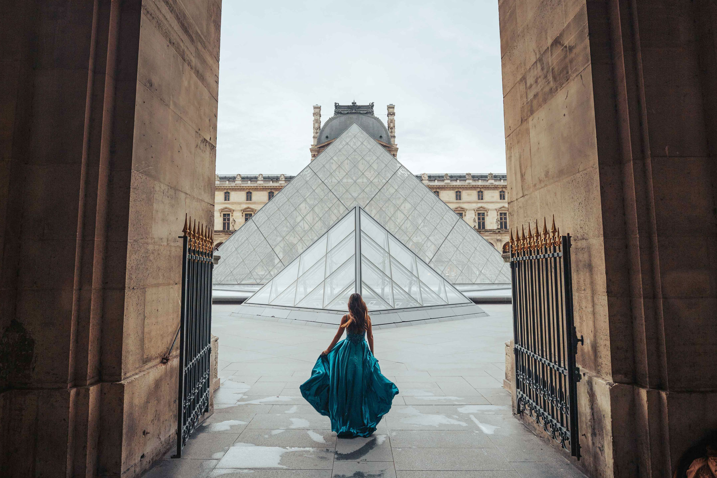 Woman in formal dress walking towards the entrance of the Louvre, Paris, France