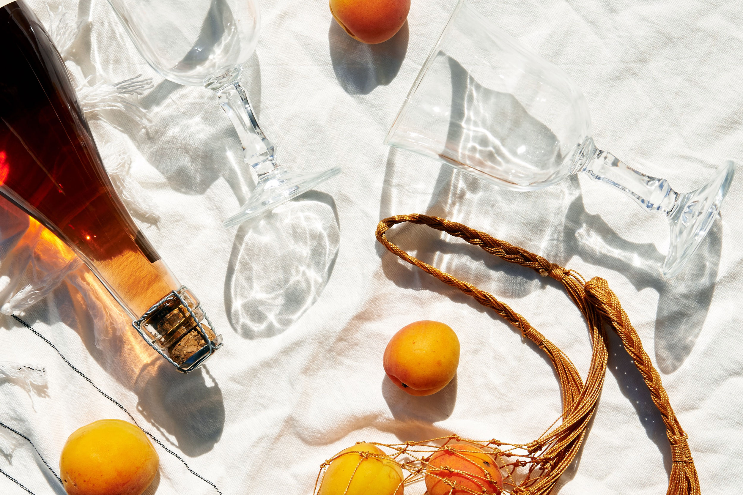 Flatlay of apricots, wine, glasses