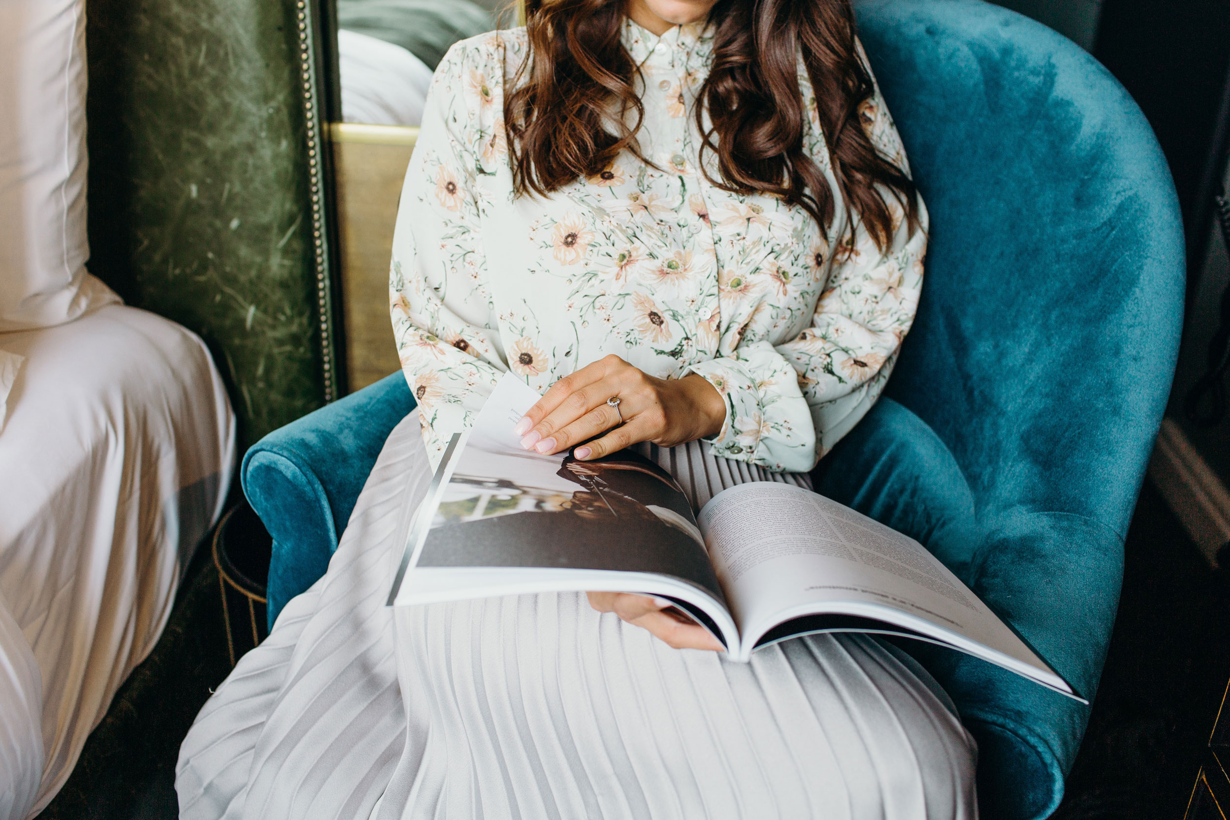 Woman reading in blue chair.
