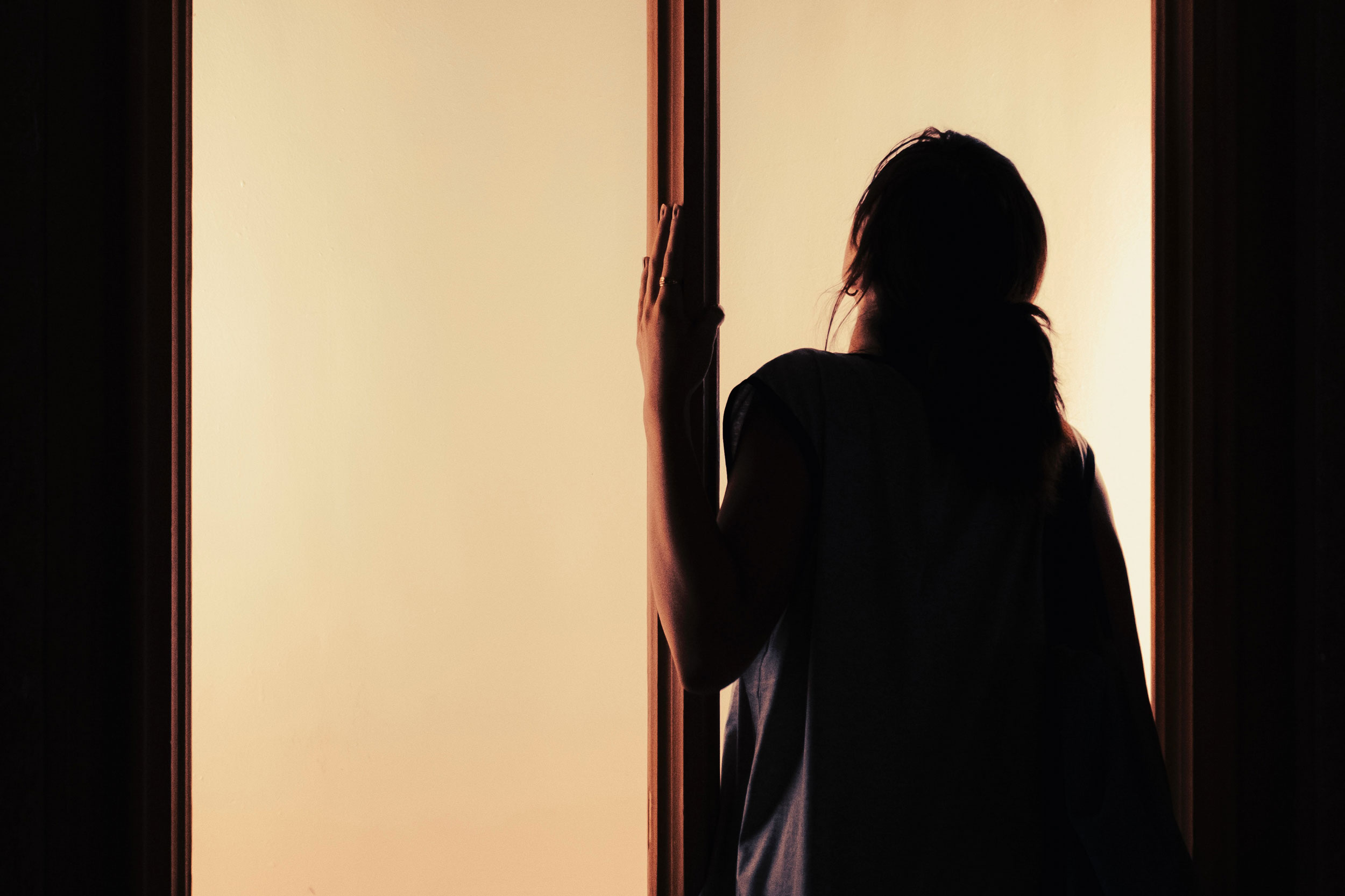 Woman at window in shadows